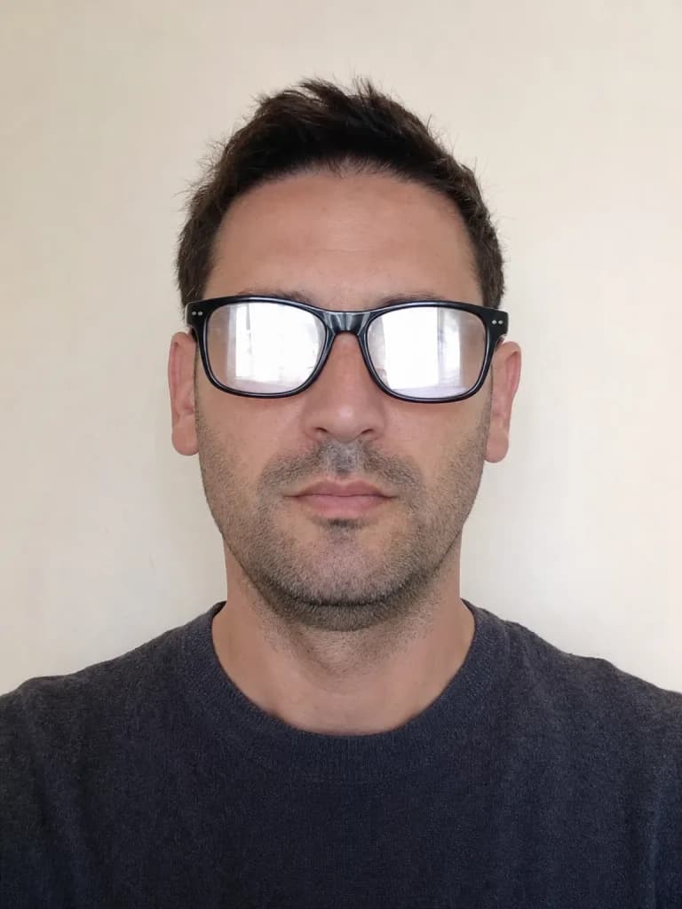 Foto de carnet rebutjada: el reflex de la finestra als vidres de les ulleres tapa completament els ulls.